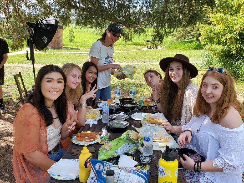 Picture of a group of high school seniors and a parent during a picnic after a boho session with carol's crew in lory state park.