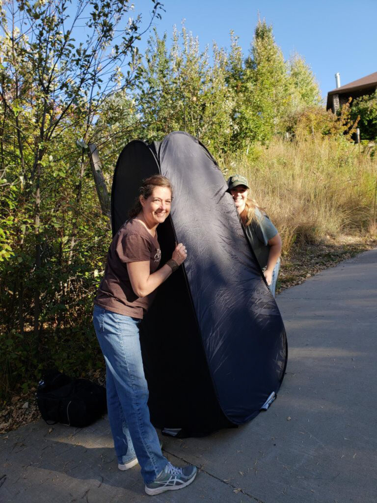 Photographer providing a private changing tent during a senior portrait session in Greeley, Colorado.