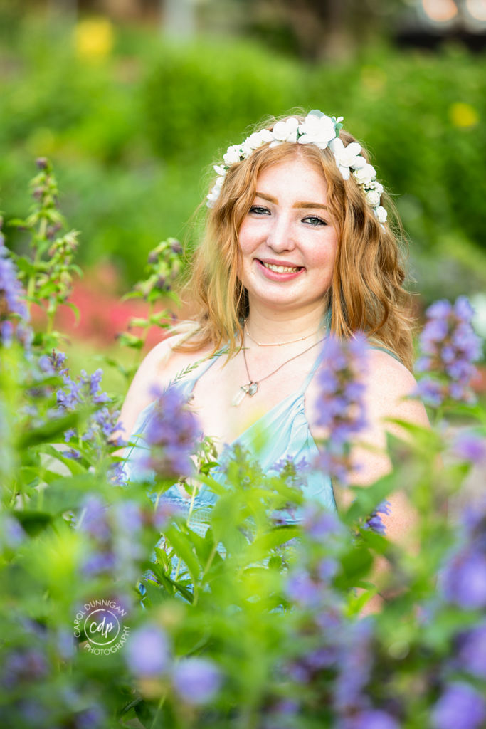 Cassie surrounded by flowers at the CSU Flower Trial Garden in Fort Collins during her senior portrait session