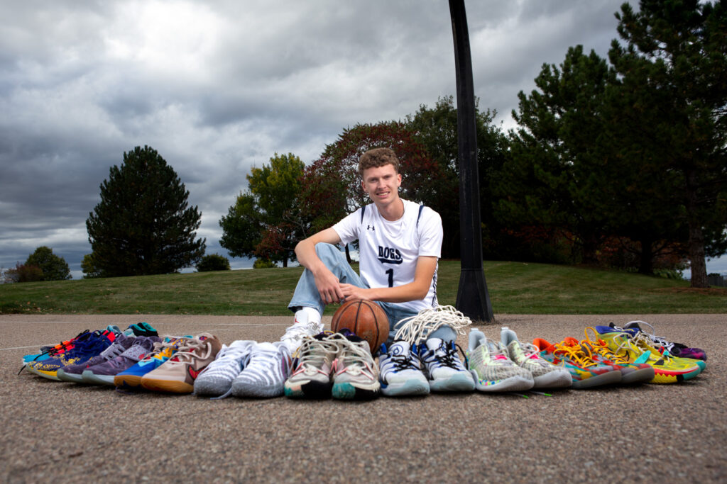 High school senior with his basketball shoe collection during a senior portrait session in Greeley, Colorado.