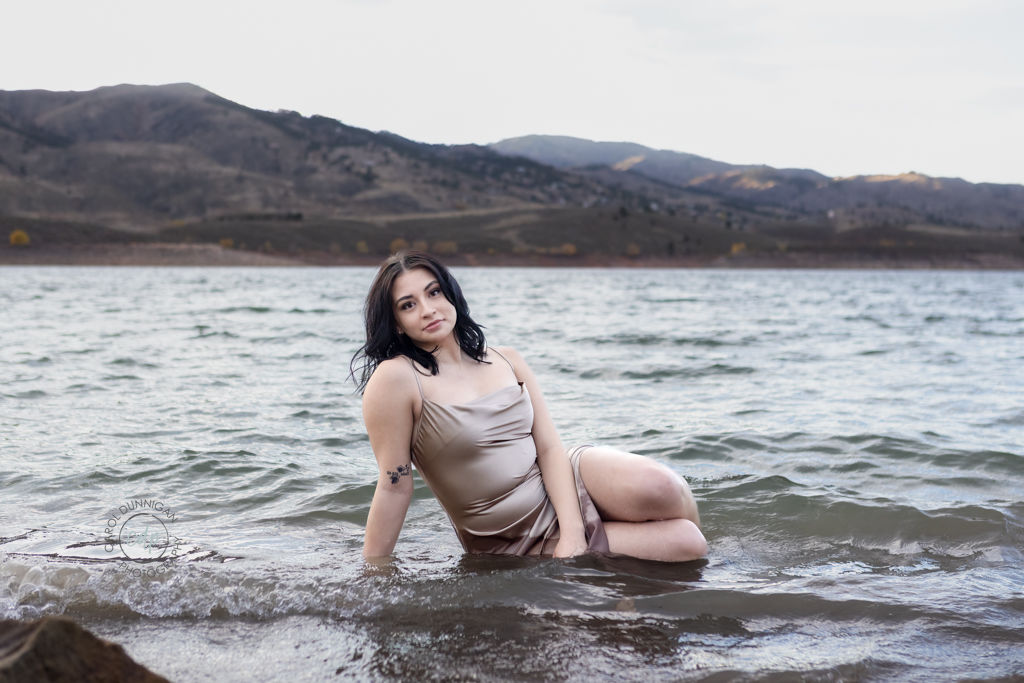 Jayna sitting in the water at Horsetooth Reservoir during her senior pictures