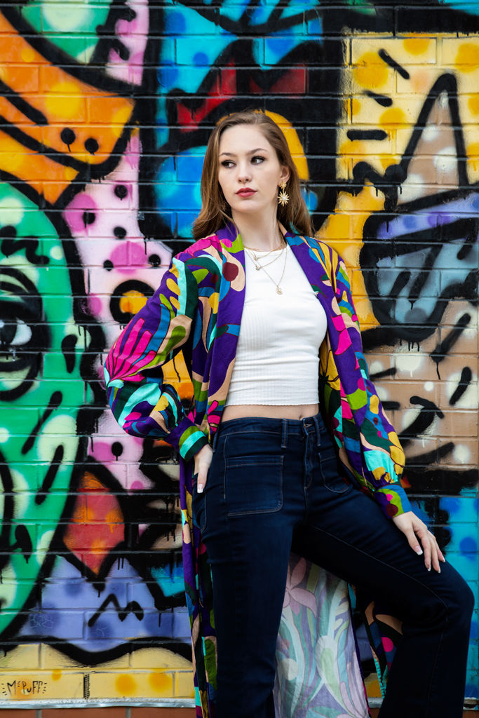 High school senior wearing a colorful cardigan over a simple outfit in Old Town Fort Collins.