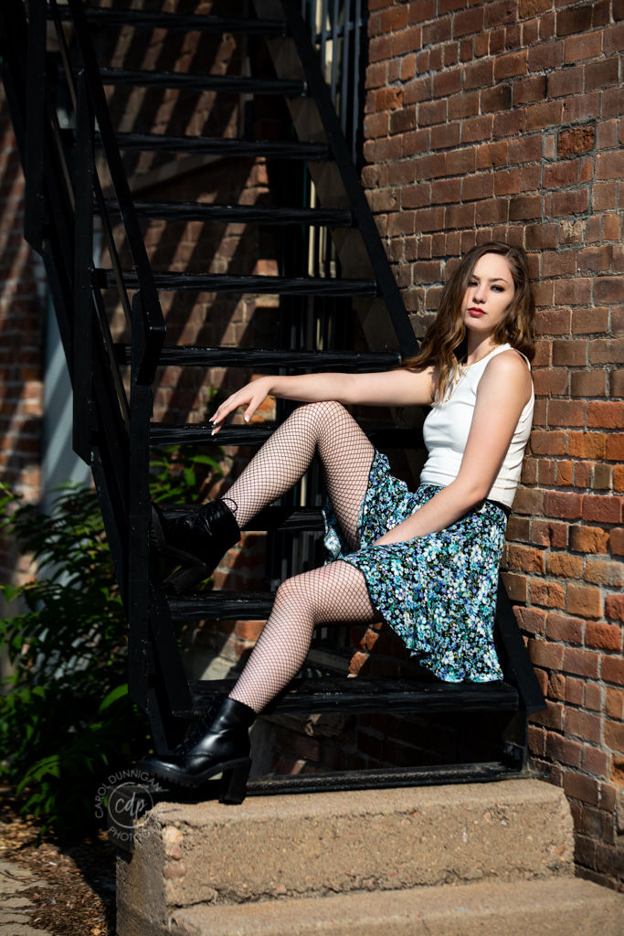 Maddie posing on a staircase in Old Town Fort Collins during her senior portrait session