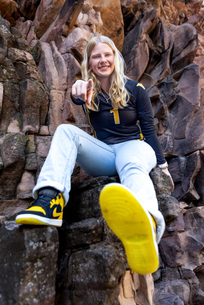 High school senior showing colorful basketball shoes during a Northern Colorado senior portrait session.