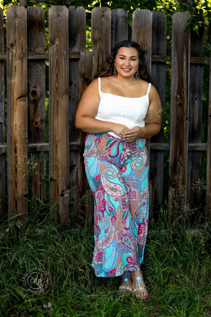 Sophia posing by a wooden fence at Lions Open Space near Fort Collins during her senior pictures