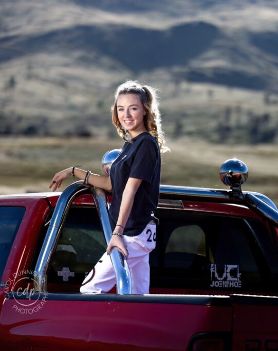 Demy posing with a red truck during her senior pictures near Loveland, Colorado