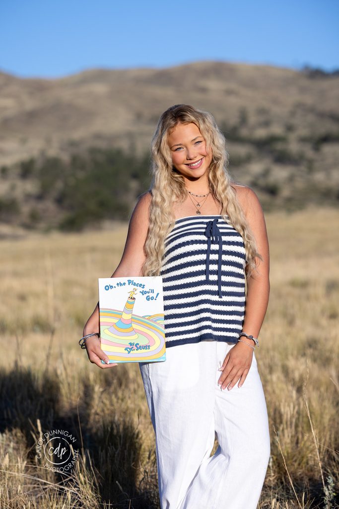 Jayda reading her Dr. Seuss book during her senior portrait session near Loveland, Colorado