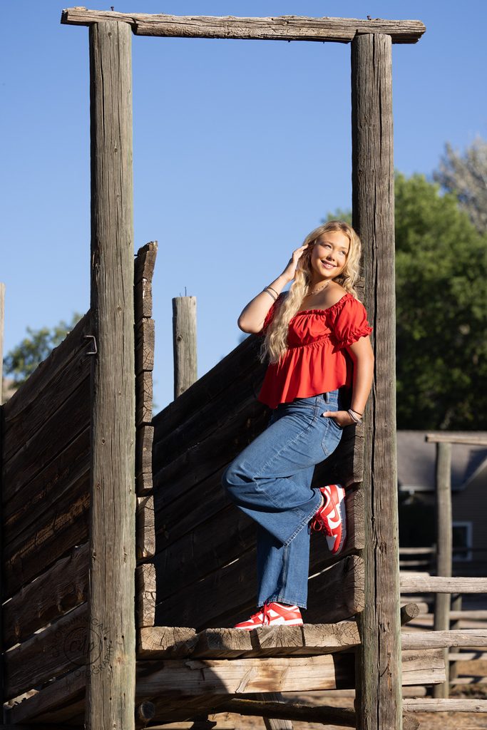 Jayda wearing a red top and jeans during her Loveland senior portrait session