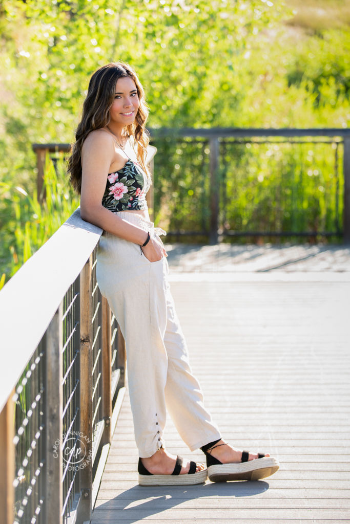 Jaymie wearing a floral top and pants during her senior portrait session at Rivers Edge Natural Area in Loveland