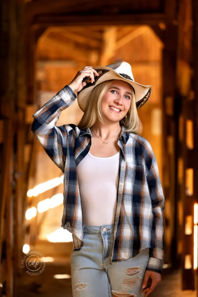 Juliaunna smiling in a cowboy hat during her senior portrait session near Loveland, Colorado