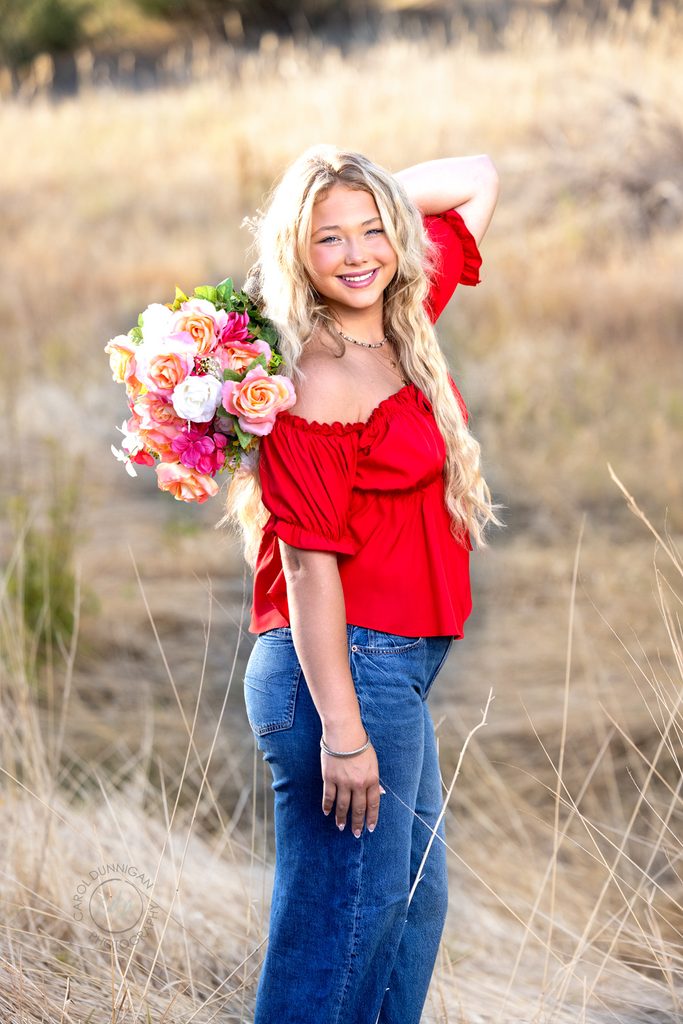 Jayda smiling during her senior pictures holding a bouquet that she made in a natural Colorado setting near Loveland