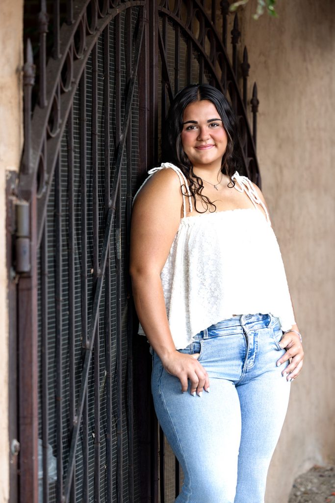 Senior girl in a white top and jeans posing for a yearbook portrait in Old Town Fort Collins.