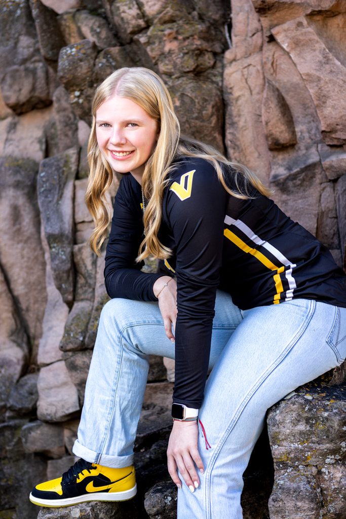 Senior girl wearing a black and yellow Valley High School sports jersey posing for a yearbook portrait in Lyons.