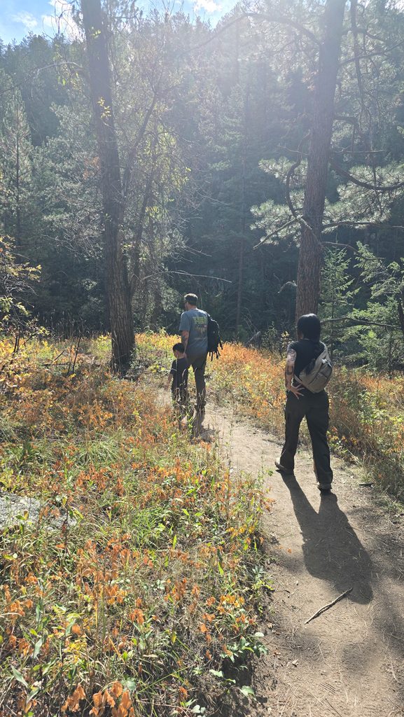 Hikers walking along the Anne U. White Trail through fall vegetation in Boulder, Colorado