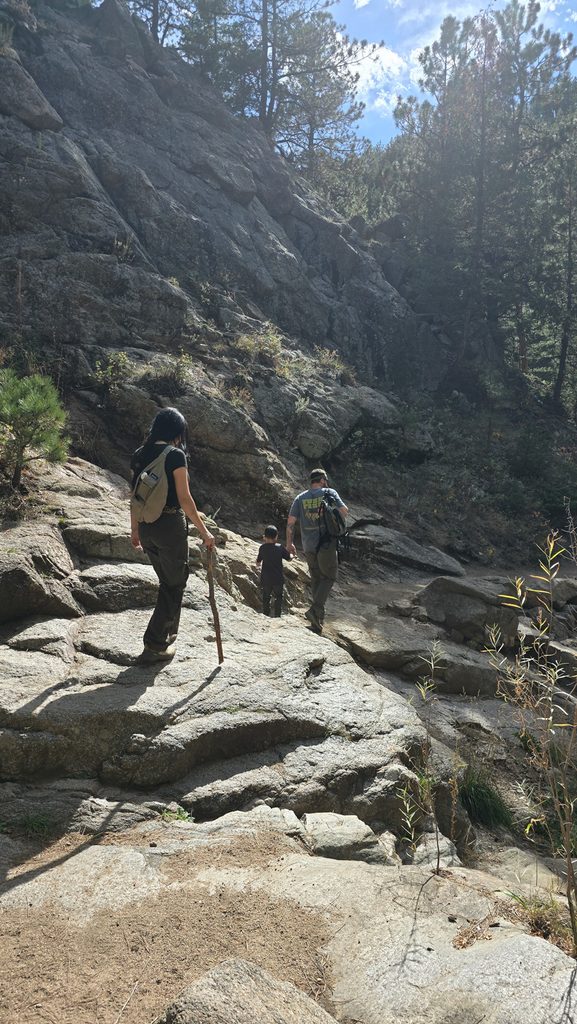 Family hiking over a rocky section of the Anne U. White Trail