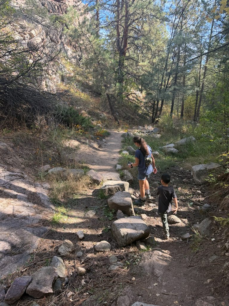 Family hiking along a rocky section of the Anne U. White Trail in Boulder