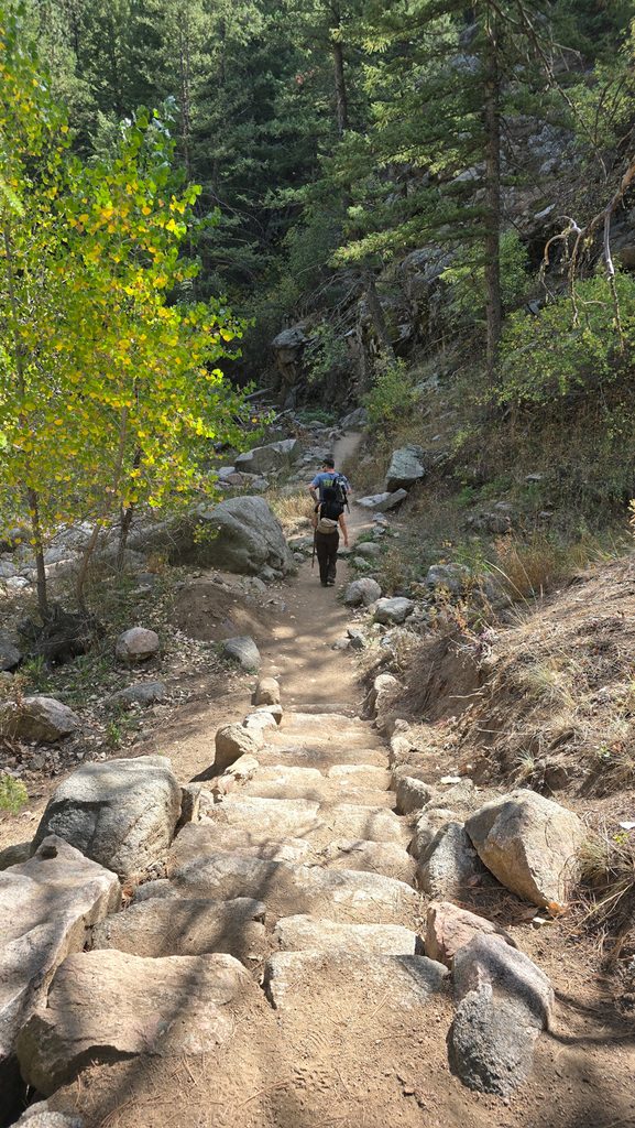Hiker climbing rocky steps along the Anne U. White Trail
